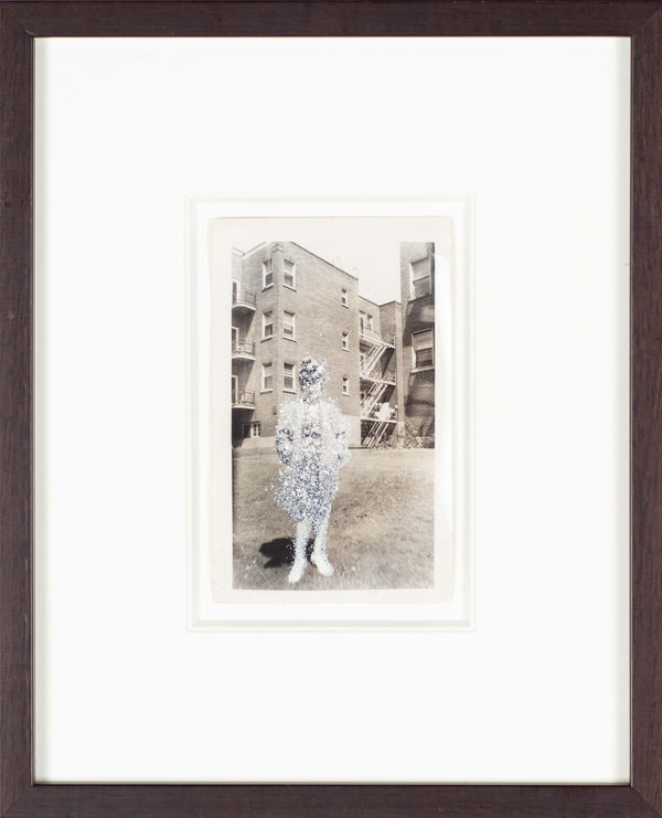 John Latour, Woman wearing a floral dress, over-sized jacket and hat standing in front of apartment, 2008