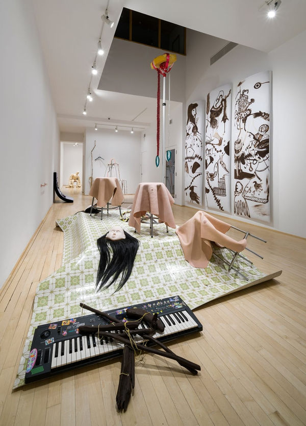 Scène de crime Peaux, banc, corde-couteau, prélart, socle, vidéo sur tv au sol avec une couverture de chien, faucille, couteau, masques avec perruques, synthétiseur, bois de grève peint brun, porte serviette, l'arbre-suçon, ventilateur Geneviève et Matthieu Variable