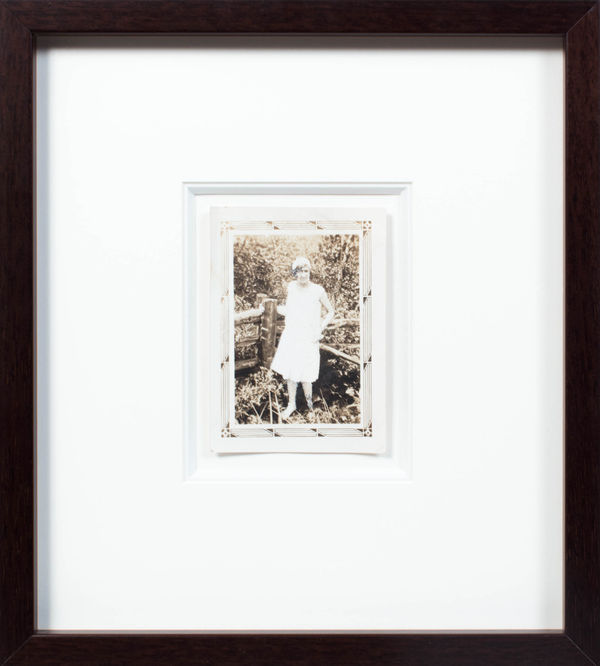 John Latour, Young woman in white dress and pearls holding onto a fencepost / Jeune femme en robe blanche et perles s’appuyant sur un piquet de clôture, 2015