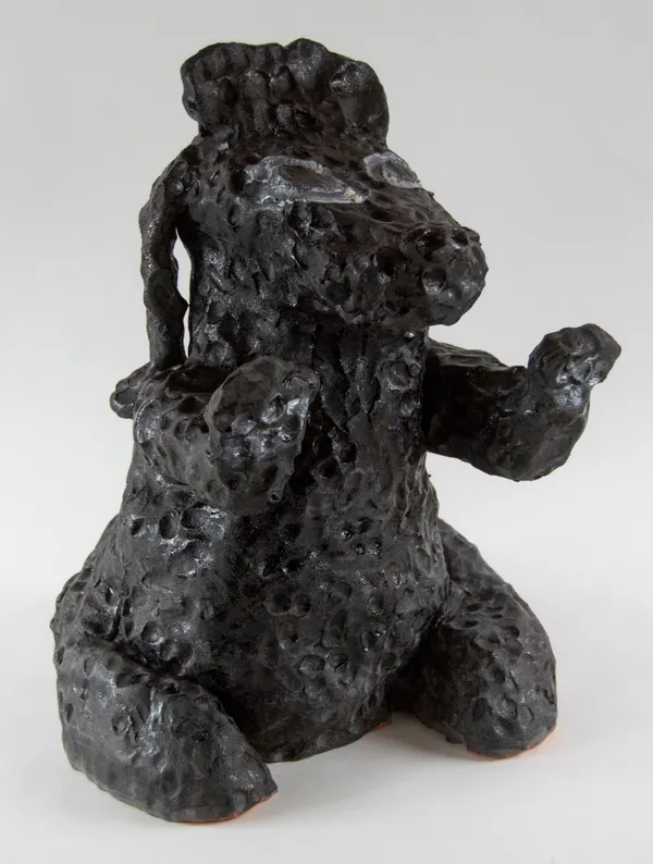 A sculpture of a black dog on its hind legs with front paws stretched out in-front of it by by artist Reniel Del Rosario.