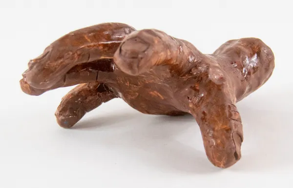 A clay sculpture of a hand with fingers spread to gesture reaching out by artist Reniel Del Rosario.