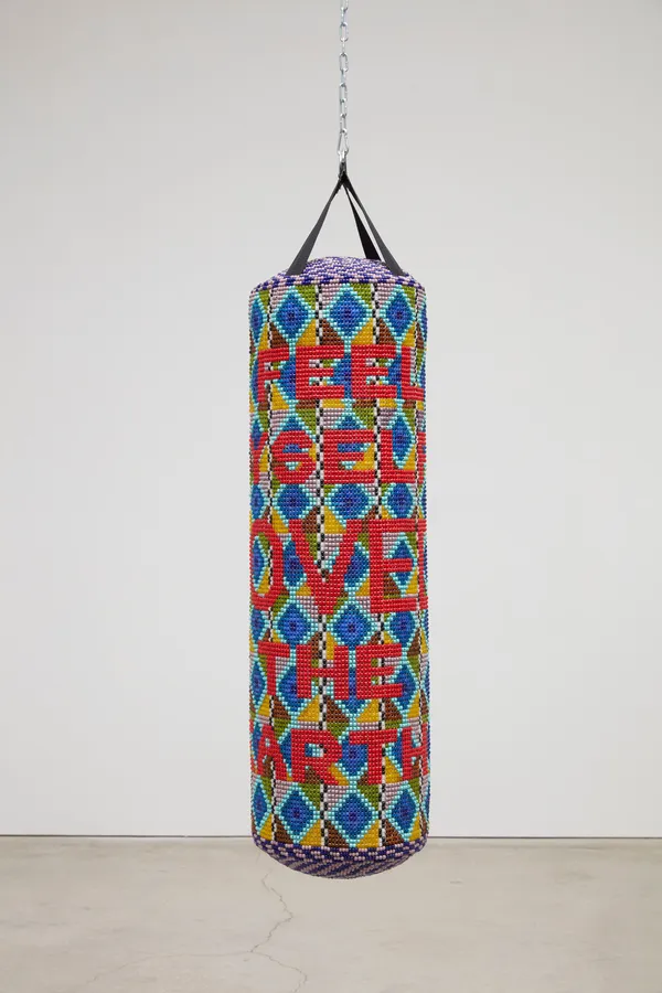 Jeffrey Gibson TO FEEL MYSELF BELOVED ON THE EARTH, 2020 Found Punching Bag, Expanding Foam, Acrylic Felt, Plastic Beads, Glass Beads, Artificial Sinew 57 x 15 x 15 inches 144.8 x 38.1 x 38.1 cm