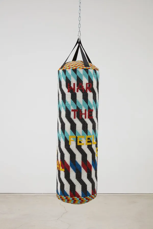 Jeffrey Gibson WAR IS NOT THE ANSWER FEEL SOMETHING REAL, 2020 Repurposed Punching Bag, Acrylic Felt, Glass Beads, Artificial Sinew 57 x 15 x 15 inches 144.8 x 38.1 x 38.1 cm