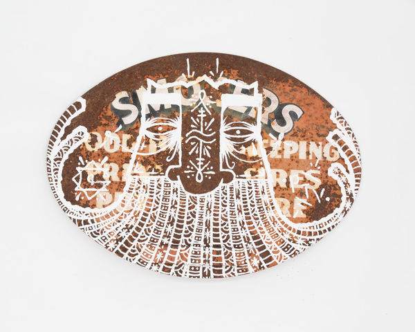 Circular rusted metal sign with GATS character drawn in white.