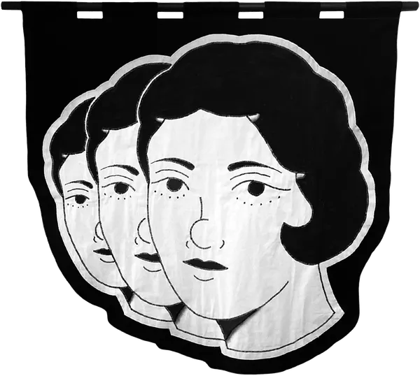 embroidered black and white banner of the heads of three woman in an angled row