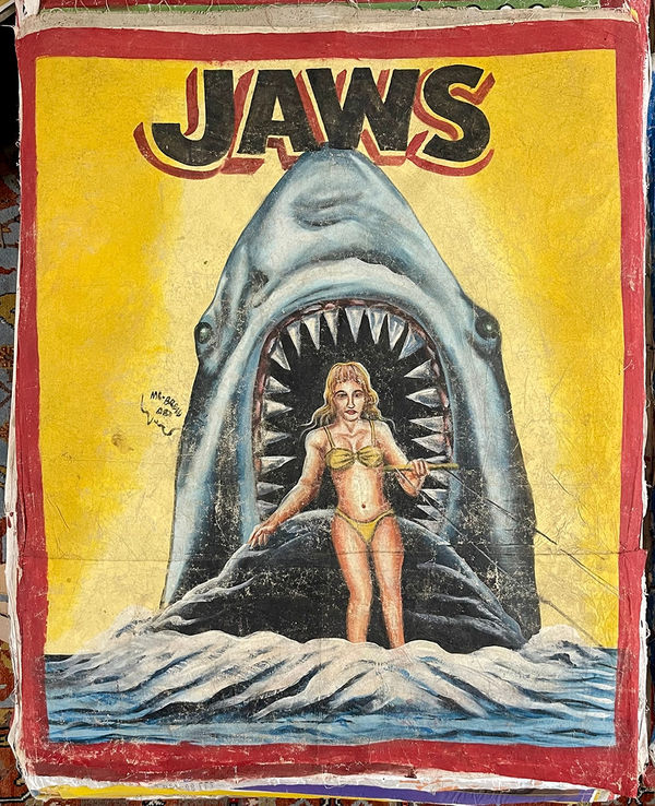 Painted poster for the movie "Jaws" of a woman in a bathing suit riding a wave with a huge shark behind her