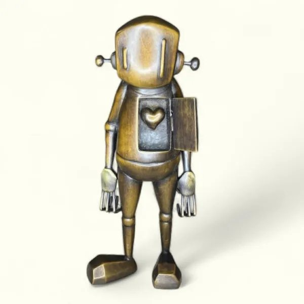 front view of a bronze robot statue with an open door on his chest revealing a heart