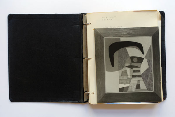 Open three-ring binder showing black and white abstract composition with a large dark curve hanging over two small stacks of lines