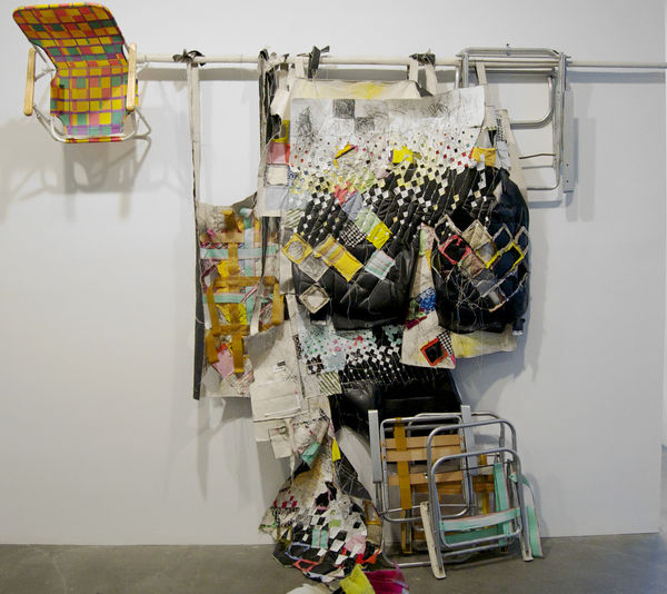 Installation view of lawn chairs and detritus installed against a wall