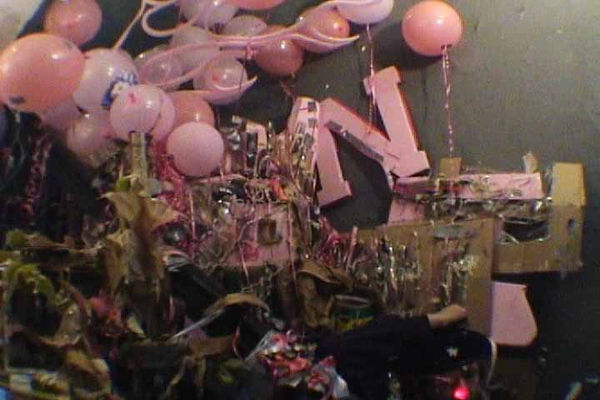 Pink party balloons creep across a video still