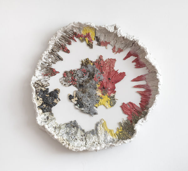 Large ceramic circle surrounding a flat irregular circle, painted in white, grey, yellow and red