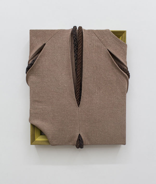 Rough brown fabric stretched over rectangle frame, frame reveal lower left, lined dark brown slits center top and bottom, diagonal slits left and right upper quadrant