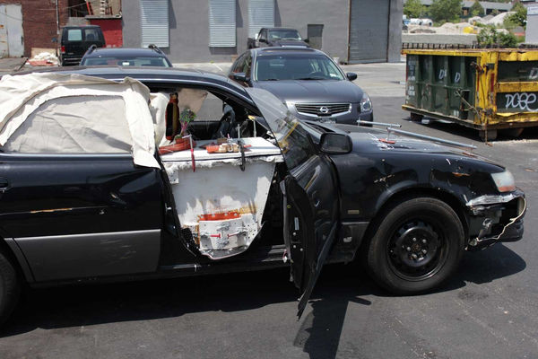Still image from video showing car with an open door revealing a makeshift desk