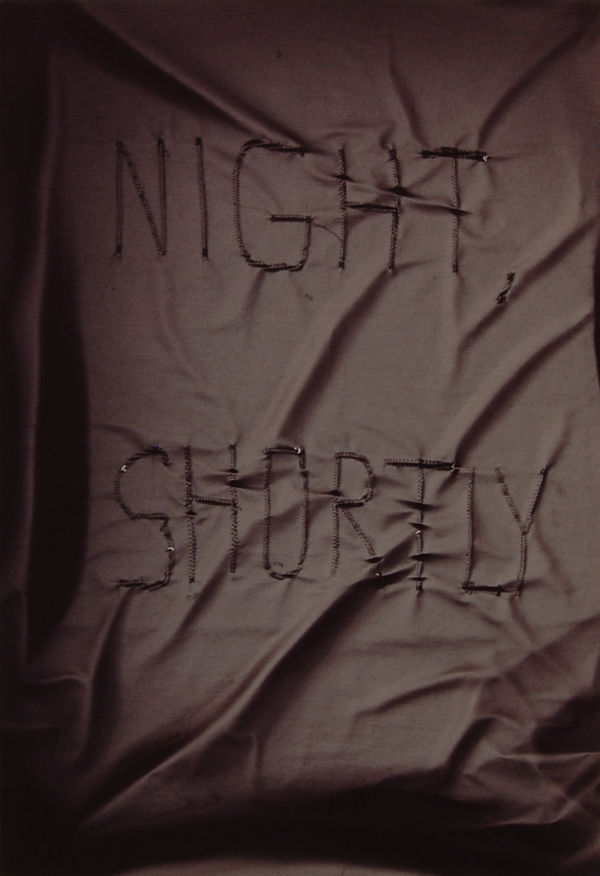 Black fabric with text in black, Night Shortly