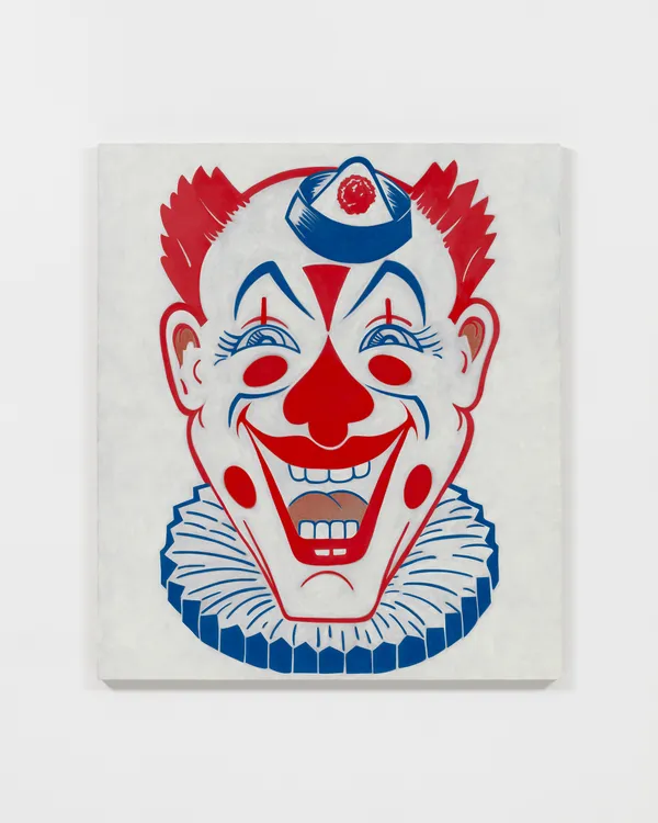 Red and blue graphic clown face against white background on white wall