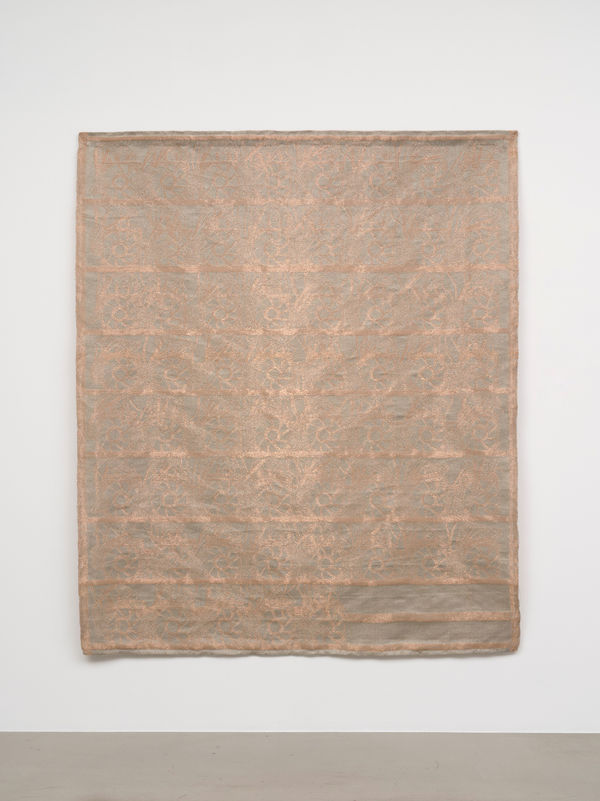 a slightly shimmery large scale copper weaving on a white wall