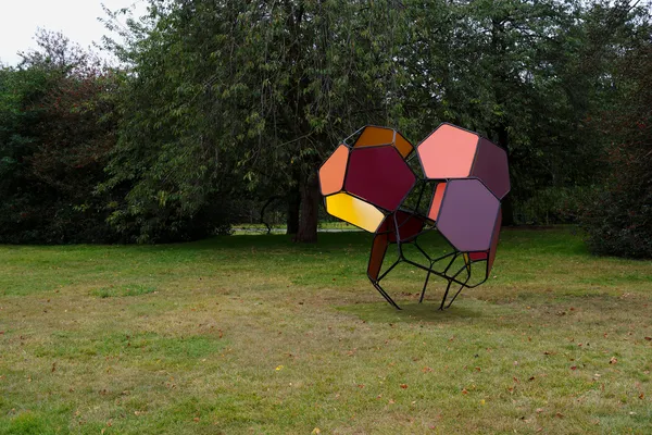 a large scale module sculpture in a green park