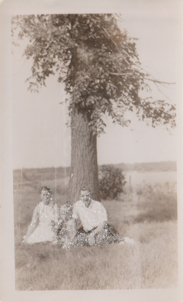 Mother and father sitting under a tree with their son holding a bunch of flowers, 2024 6 x 3.7 in., Framed size: 12.2 x 10.25 in. John Latour Found photograph with acrylic paint