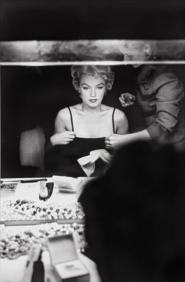 Marilyn Monroe looking at her makeup in the dressing room mirror of Carol Haney in New York City, 1954