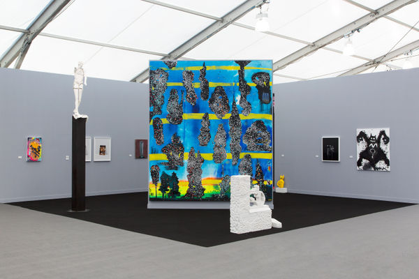 Installation view at the fair. Gray walls and works scattered among them. Many large paintings are shown.