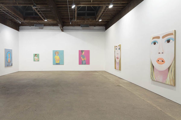 Installation view of Brian Calvin's fourth show at Anton Kern Gallery, featuring a group of paintings of faces, lips, mouths, poses, and a mirror. Distanced view of the gallery, showing many works.