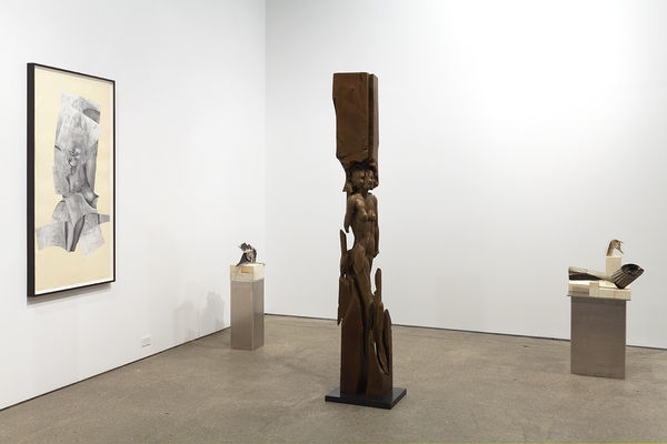 Installation view of Matthew Monahan's sixth solo show at Anton Kern Gallery, featuring sixteen sculptures, a set of drawings, two wall-mounted masks, and a single large figure in the back room.