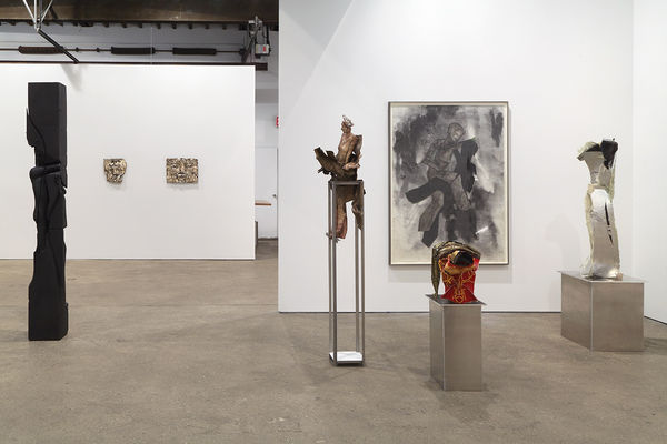 Installation view of Matthew Monahan's sixth solo show at Anton Kern Gallery, featuring sixteen sculptures, a set of drawings, two wall-mounted masks, and a single large figure in the back room. Some more works.