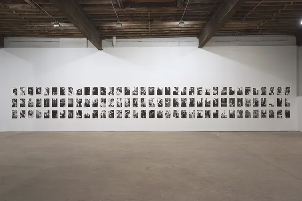 Installation view of Nobuyoshi Araki's first solo exhibition, consisting of diaristic photos from the 1960s and early '70s. Another wall of photographs.