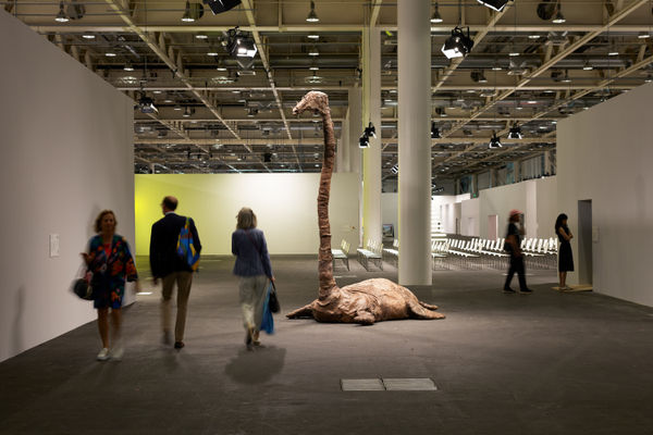 Installation view of Art Basel Unlimited 2023 with view of floors, walls, viewers, ceiling, and artwork by Francis Upritchard.