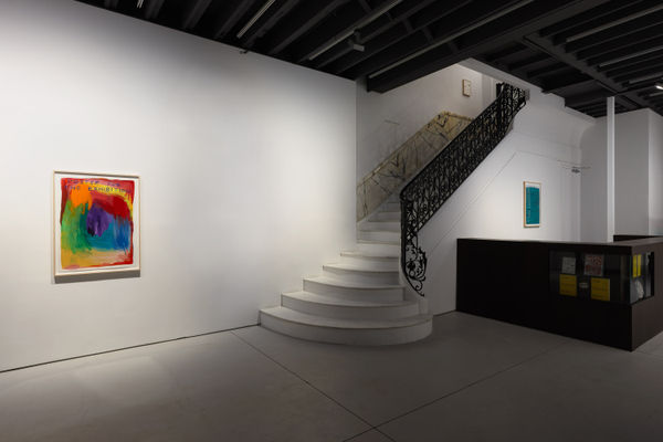 Installation view of David Shrigley's solo exhibition at the gallery with about 100 paintings and sculptures. Work next to entry stairwell.