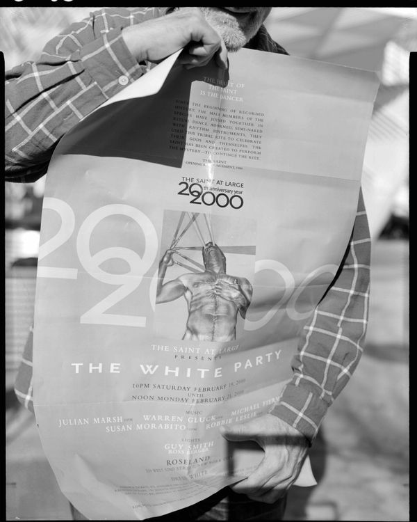 Ian Lewandowski Gil unfurling a The Saint at Large poster commemorating the 20th anniversary of the opening of The Saint, AIDS Memorial Park, Greenwich Village, Manhattan. After The Saint closed its doors in 1988, it was proceeded by a series of satellite parties and..., 2020 Gelatin silver contact print 14 x 11 inches 1/4 (ed of 4 and 1 AP)