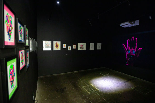 works by Alex Pardee hung on black walls