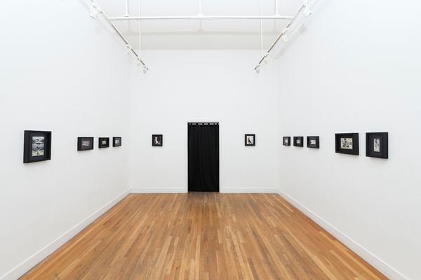 white wall with small framed works by Penny