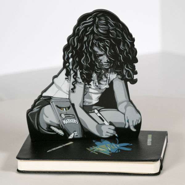 a sculpture depicting a child drawing