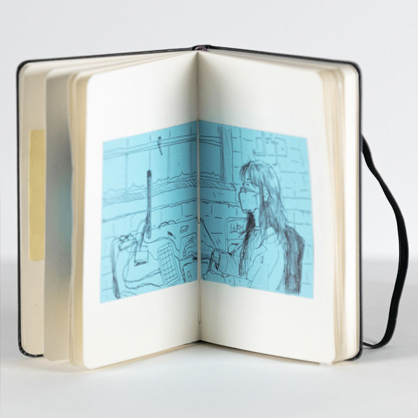 a blue sketch of a girl working at a computer on a desk