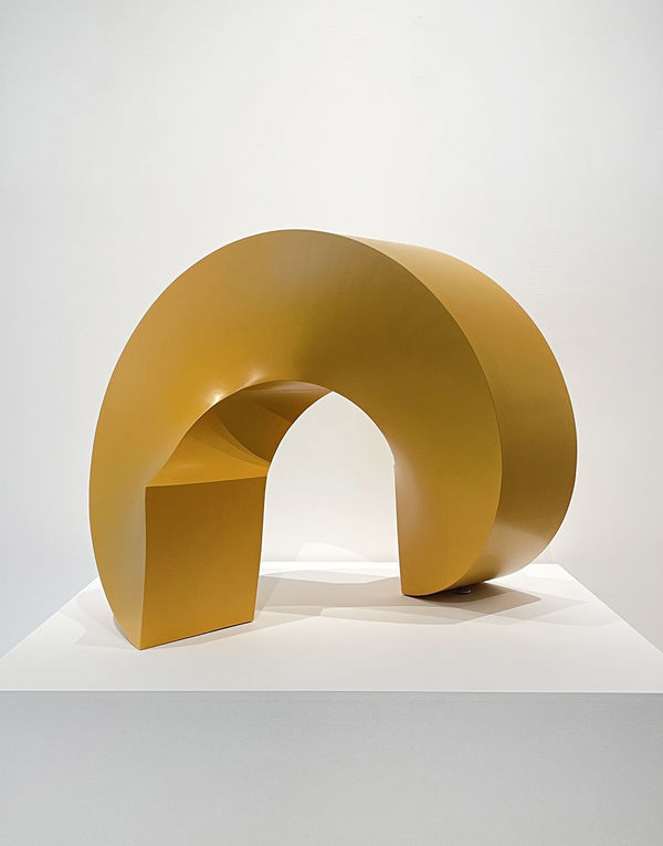 Round abstract sculpture that sits on a square base