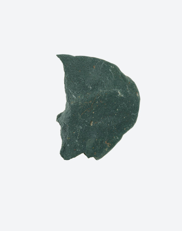A sharp, flint-like stone fragment with a glossy, dark interior revealed at the edges, isolated on white.