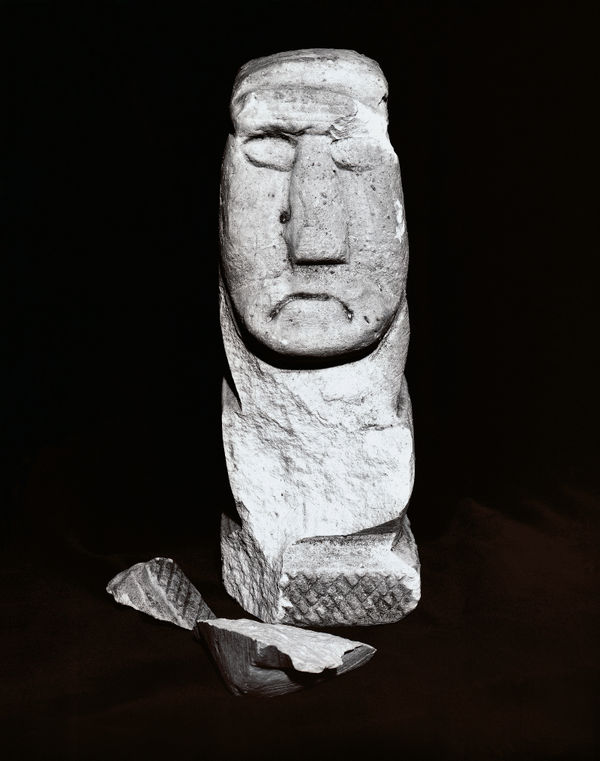 A stark black and white photograph of a wooden mask, printed from a high-contrast Kodalith negative to emphasize deep shadows.