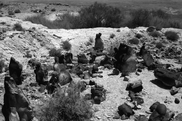 B&W photograph of dark, sculpted rock formations and ritual sites at Mount Karkom. Ariel Yannay documents the physical evidence of ancient cultic activity.
