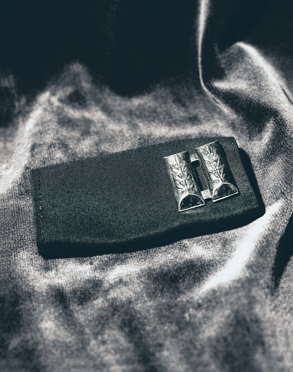 A detailed high-contrast shot of Israeli Navy rank pins and epaulettes, showing the symbolic metal shapes against a black field.