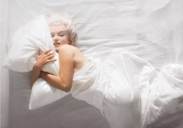 Carbon print of Marilyn Monroe from a high vantage point, wrapped in bedsheets on a bed
