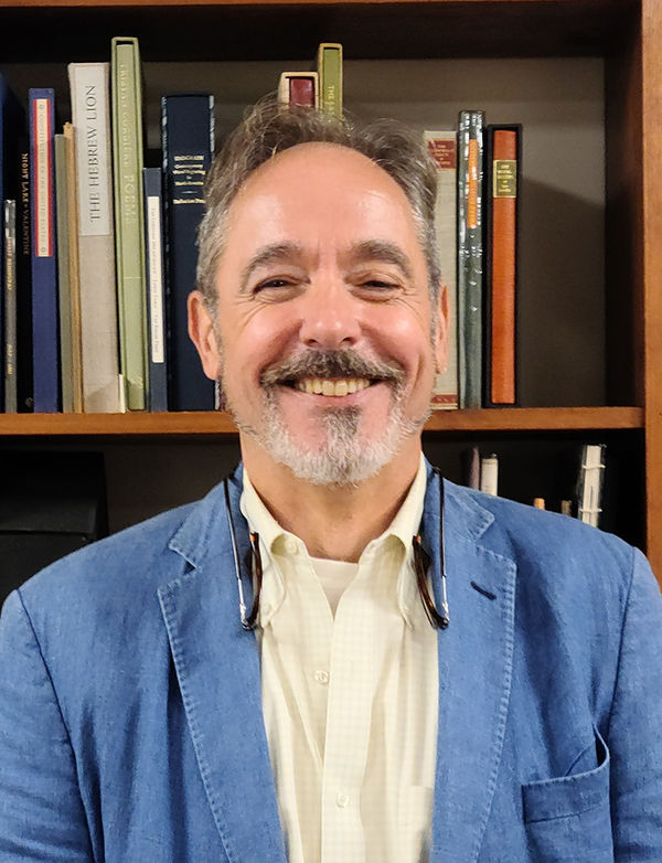 Image of Philip C. Salmon in front of a shelf of books