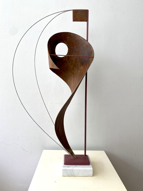 Steel sculpture with wave shape on a marble stand