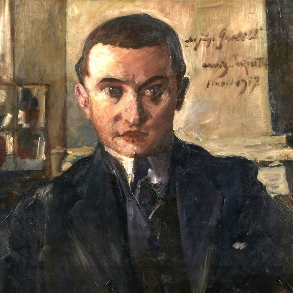 Detail from an oil painting by Lovis Corinth depicting the art dealer Wolfgang Gurlitt. The sitter has short dark hair, prominent eyebrows and nose. He wears a dark three-piece suit