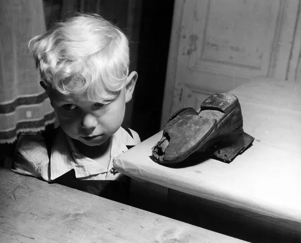 David Seymour, A little Viennese boy with his worn boot which has been brought for repair, Austria, c.1950
