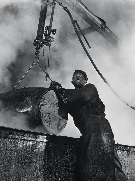 Here a workman lifts a drum from a boiling lye solution which has cleaned from it grease and dust particles, 1944