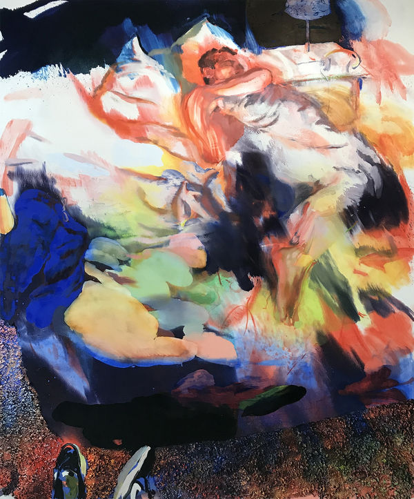 View from slightly above of a man sleeping in a bed with an assortment of blankets strewn around him.