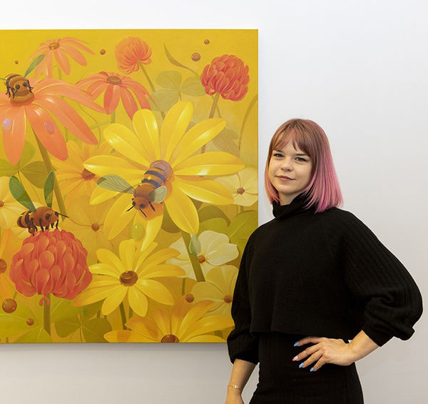 Megan Ellen Macdonald posing with one of her paintings