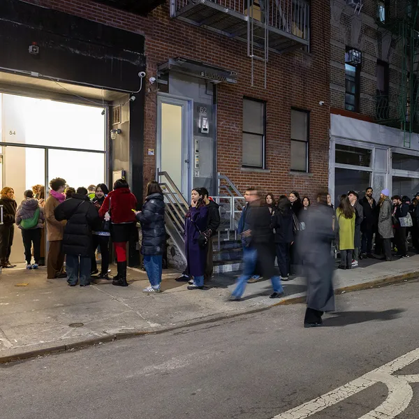 Photo of people standing on a long line in front of a gallery