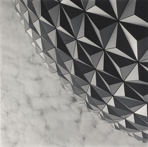 view of lower quadrant of Epcot theme park icon, Spaceship Earth, against sky with clouds